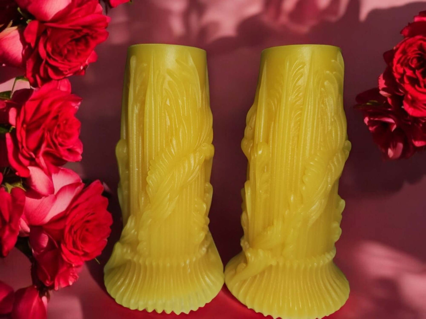 Artistic yellow candle sticks surrounded by vibrant red roses, perfect for romantic ambiance.