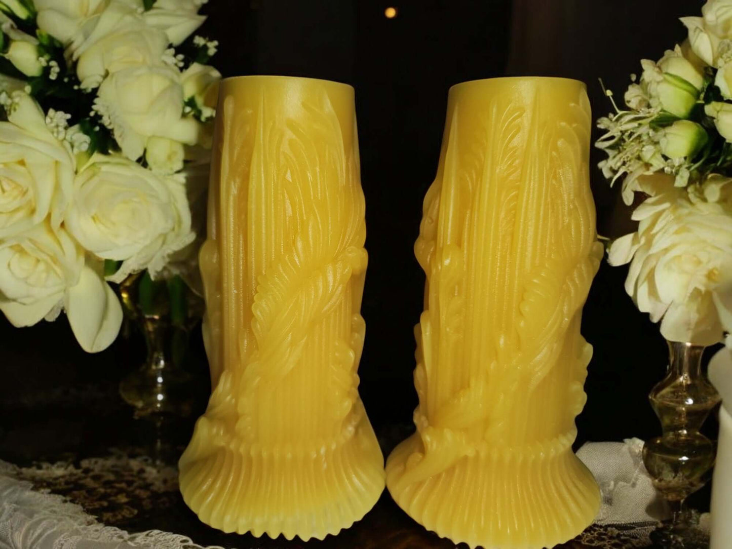 Pair of decorative yellow candle sticks surrounded by white roses, perfect for enhancing ambiance and intimacy.