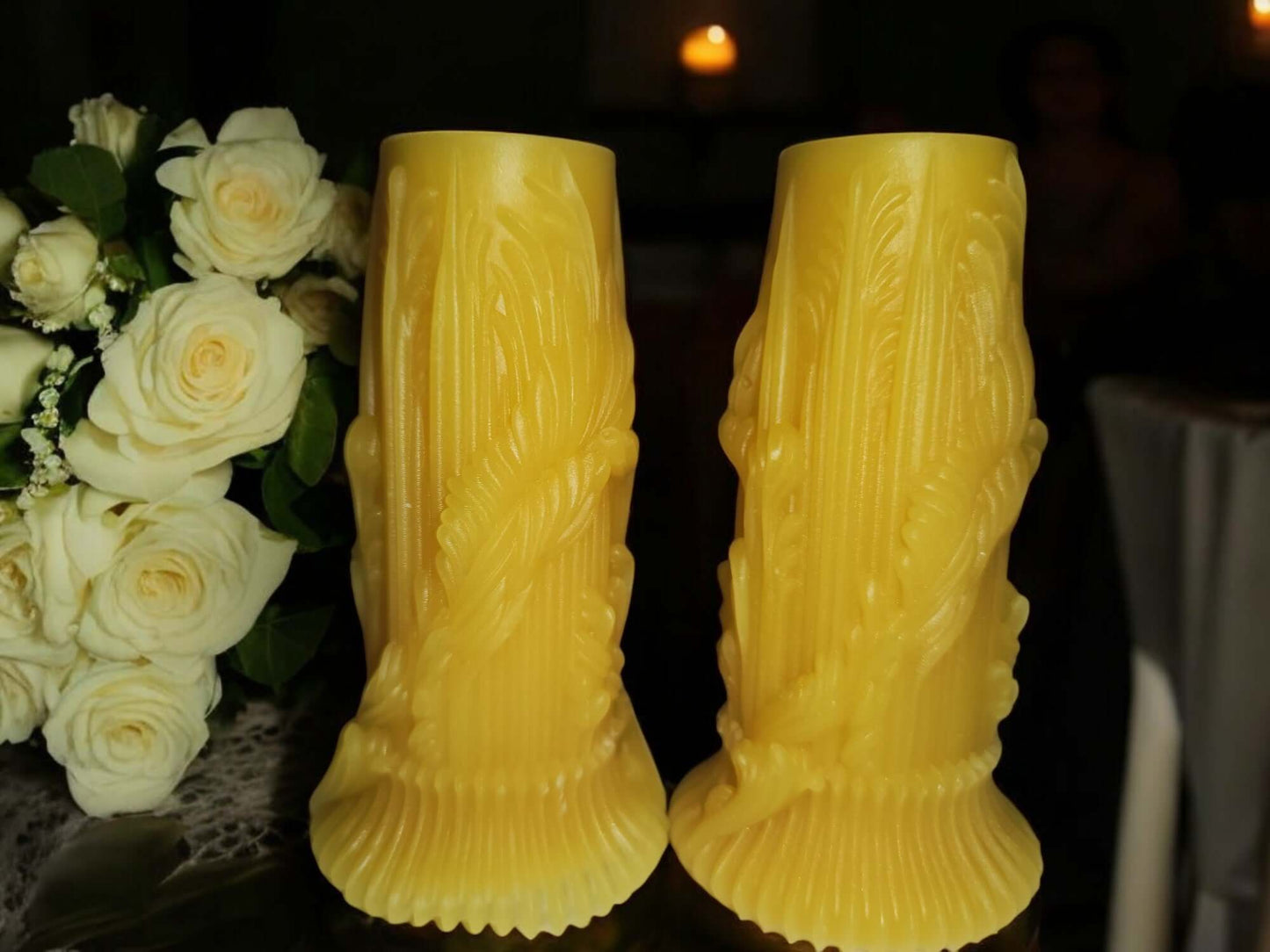 Pair of decorative yellow candle sticks beside a bouquet of white roses, creating an elegant ambiance.
