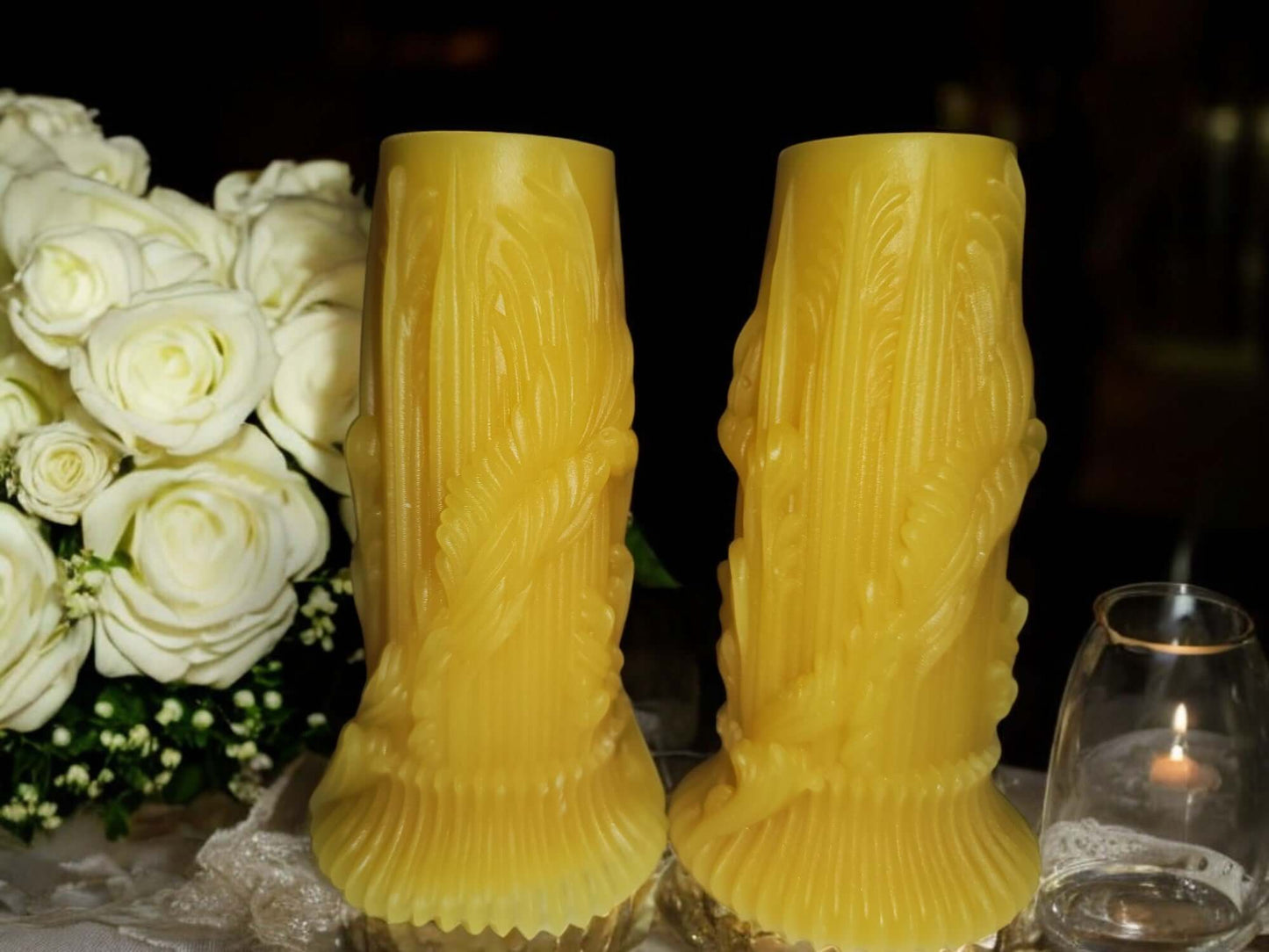 Elegant yellow massage candles beside white roses, perfect for enhancing intimacy and creating a romantic atmosphere.