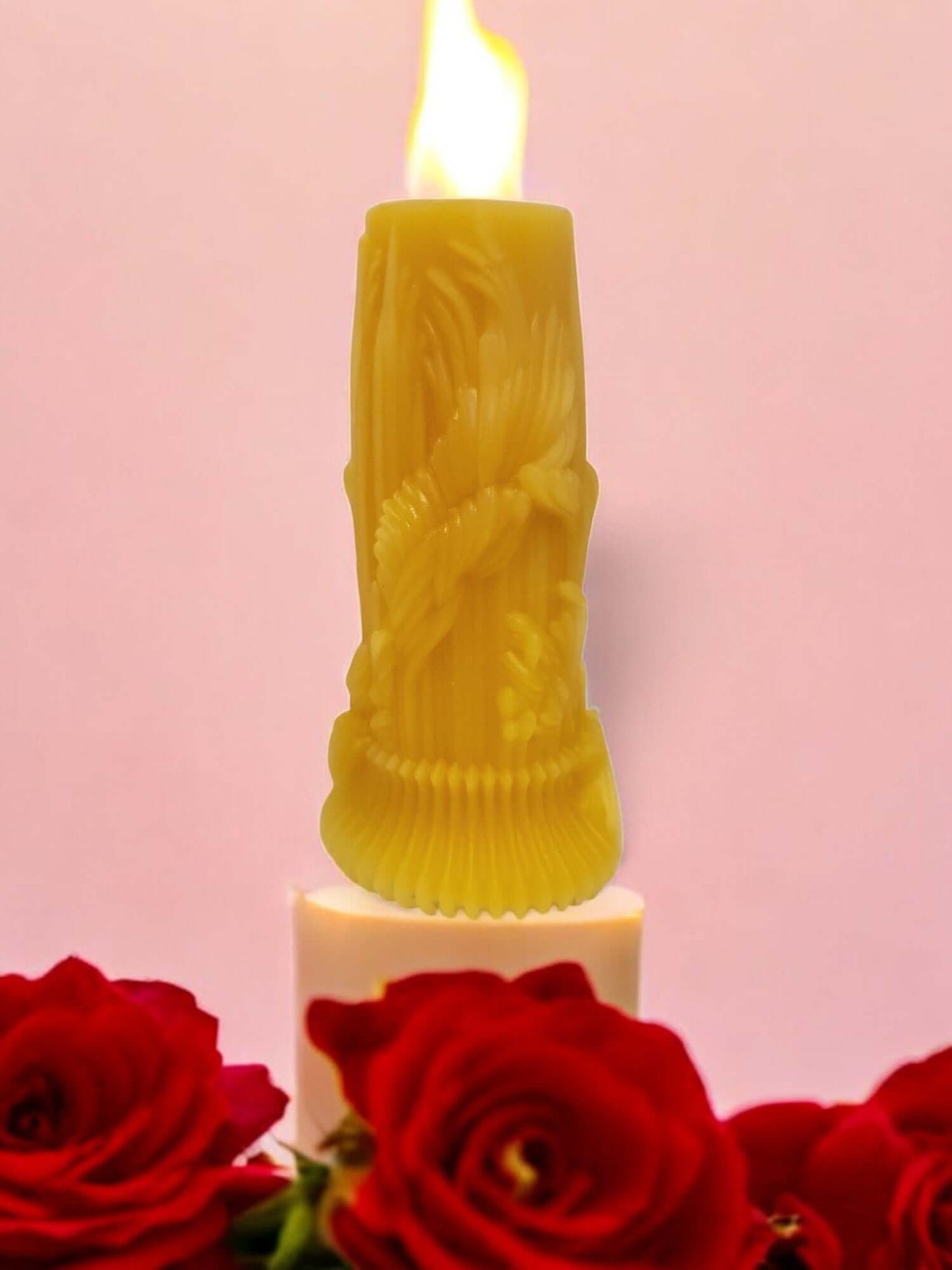 Sensual drip and massage candle burning, surrounded by red roses, creating an intimate atmosphere.
