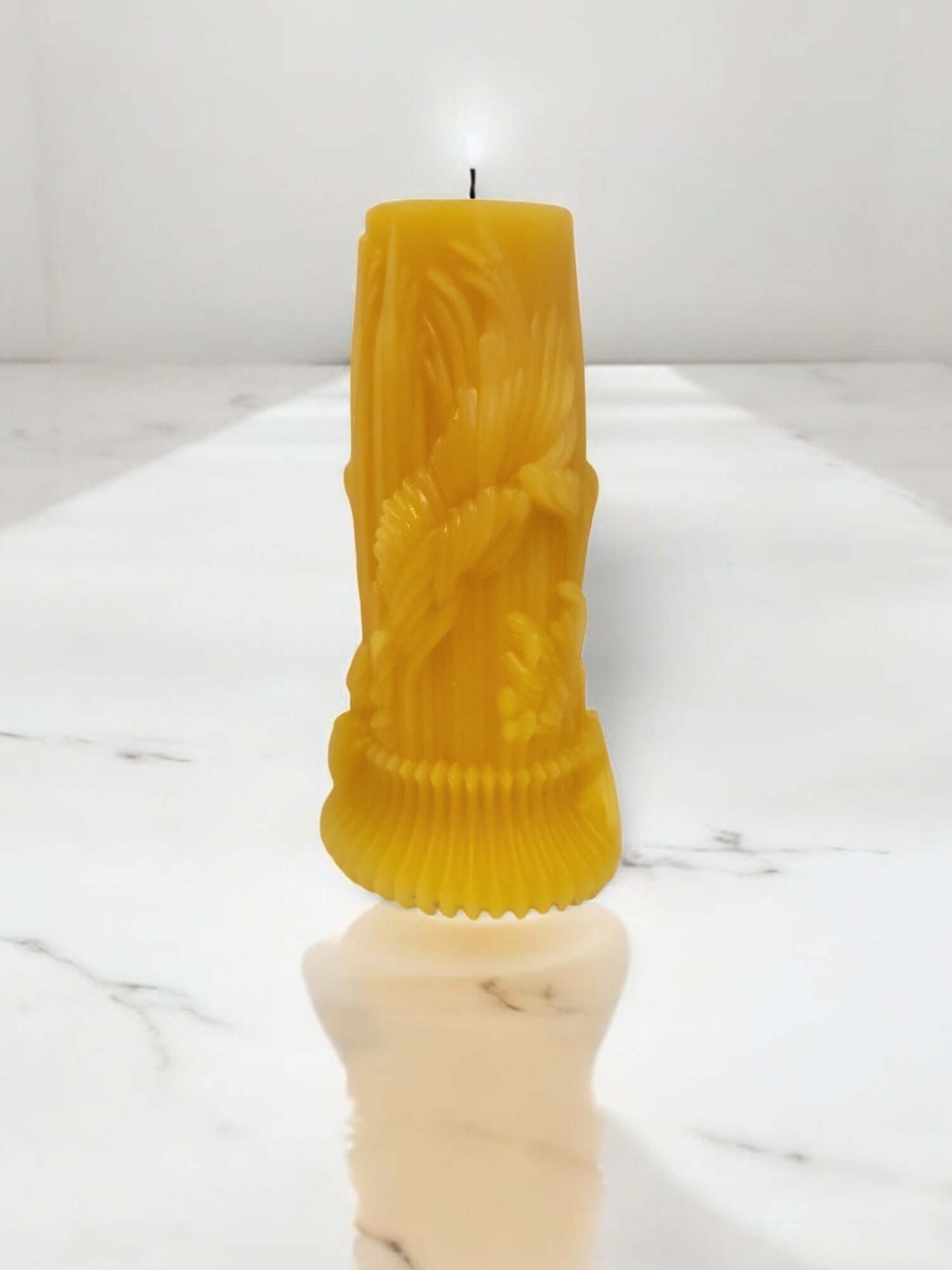 Sensual drip massage candle in vibrant yellow, designed for intimate moments and erotic play, placed on a marble surface.