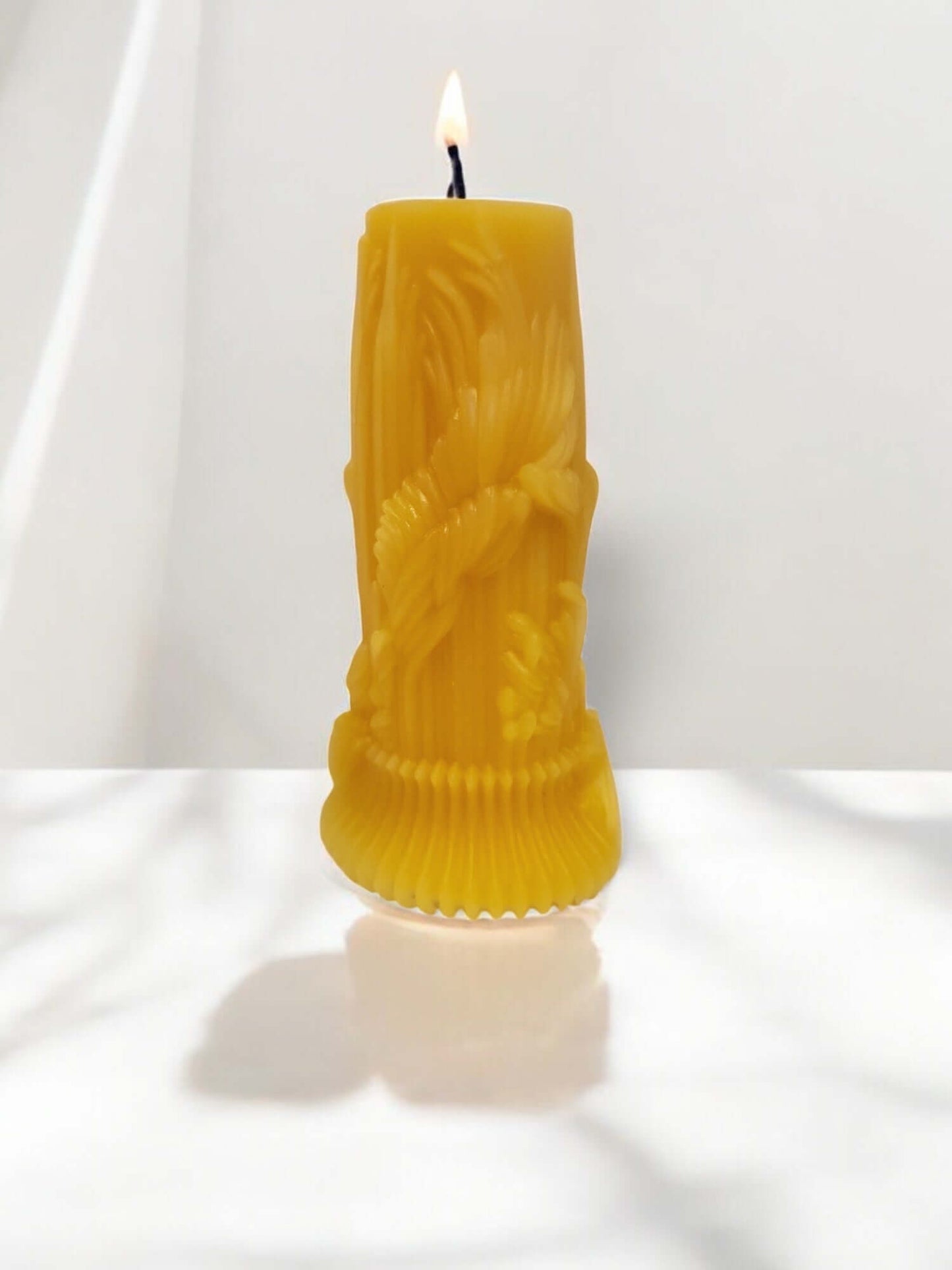 Yellow sculpted candle with a flame, ideal for sensual massage and intimate moments.