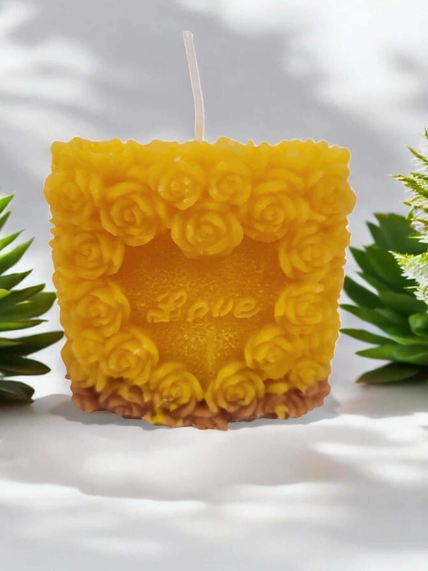 Yellow rose-themed massage candle labeled 'Love', perfect for romantic settings and intimate moments.