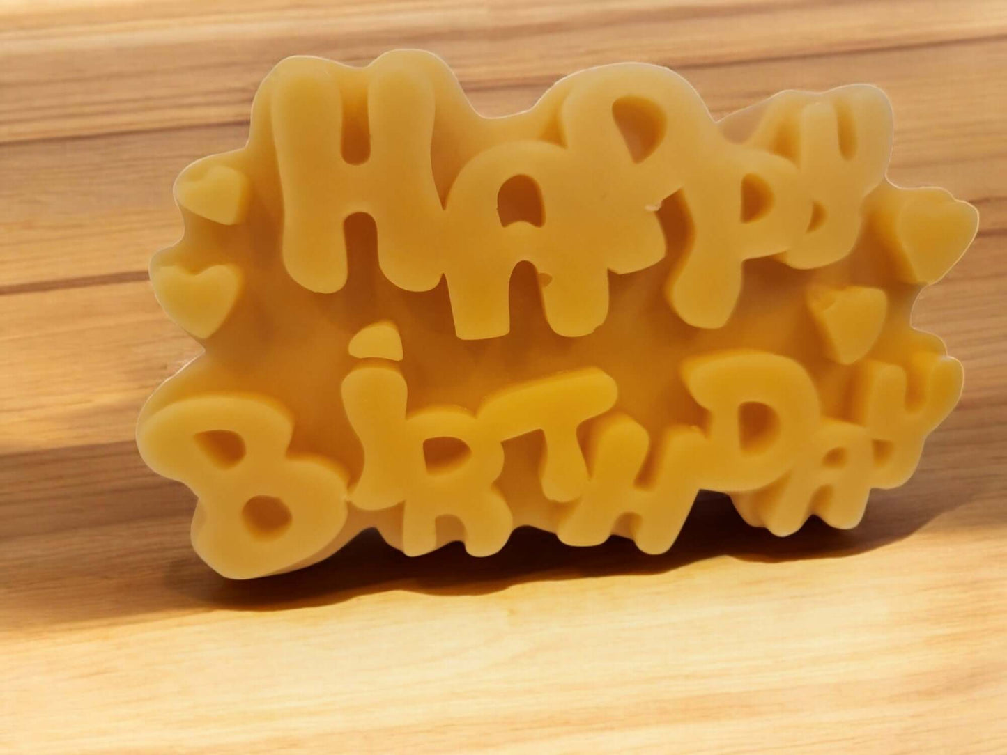 Happy Birthday candle shaped decor on a wooden surface, perfect for celebration and gifting.