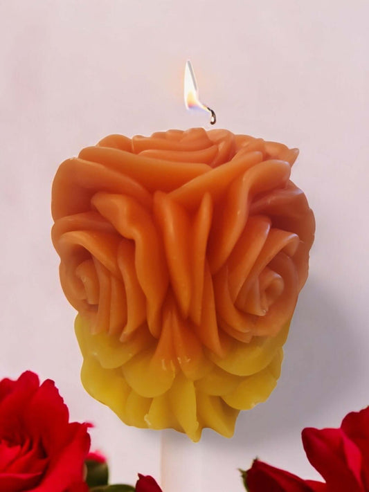 Rose-shaped massage candle melting for sensual play, with a warm glow and soft petals beside fresh roses.