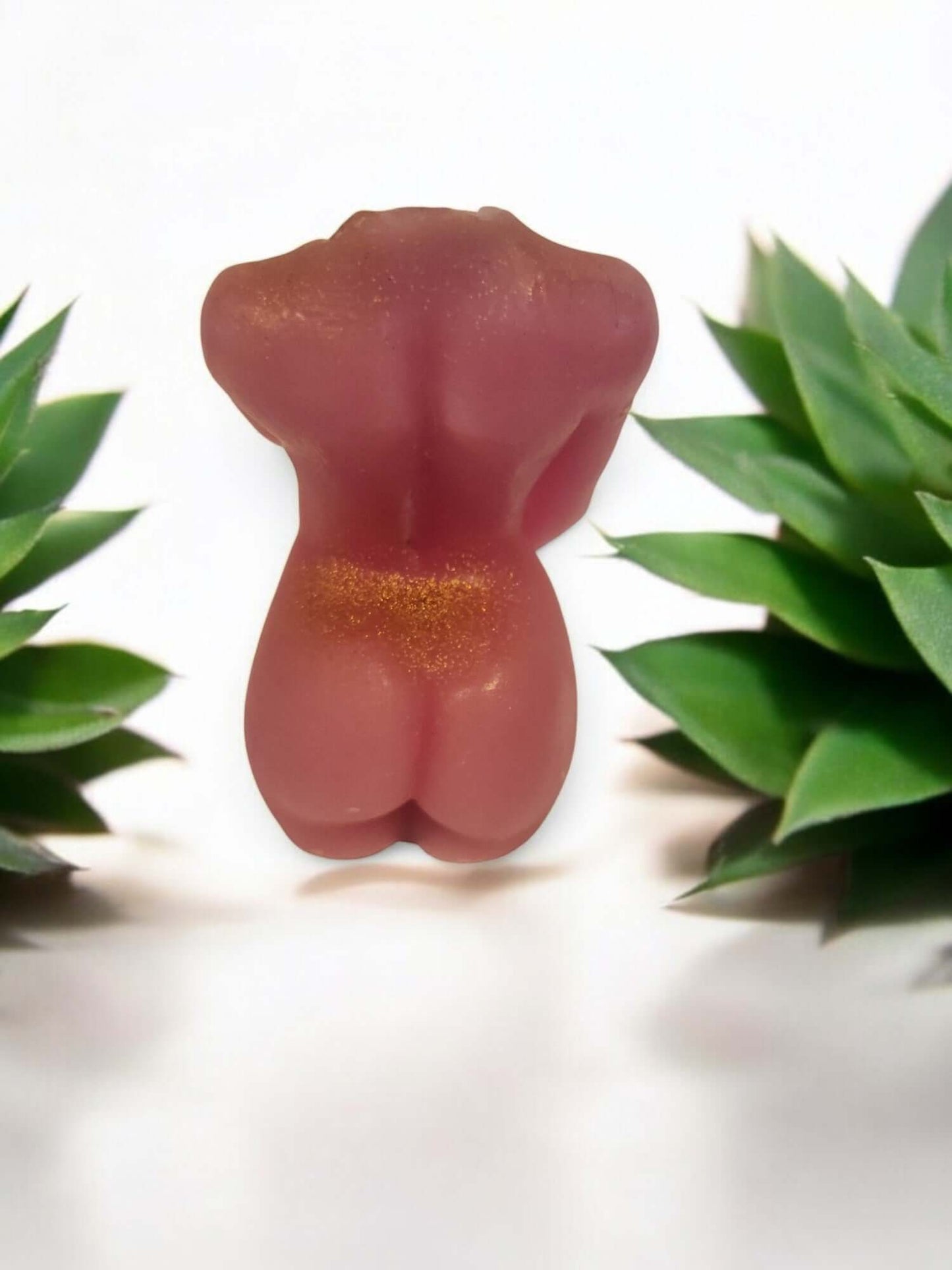 Sensual pink wax figure surrounded by green plants, ideal for intimate settings and erotic play.