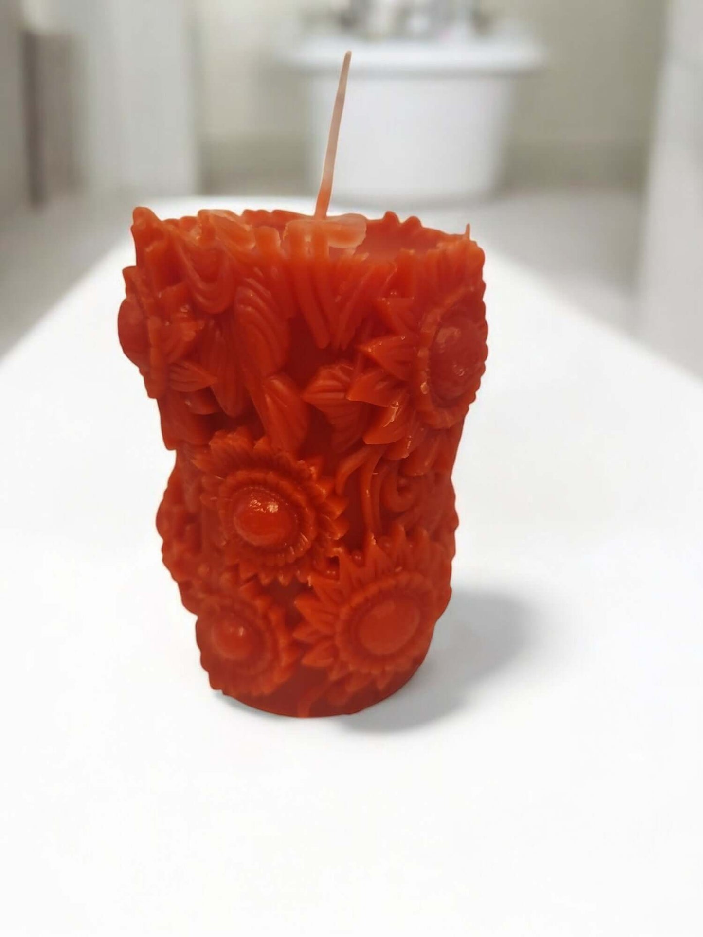 Vibrant red rose buds massage candle with intricate sunflower designs for sensual experiences and intimate moments.