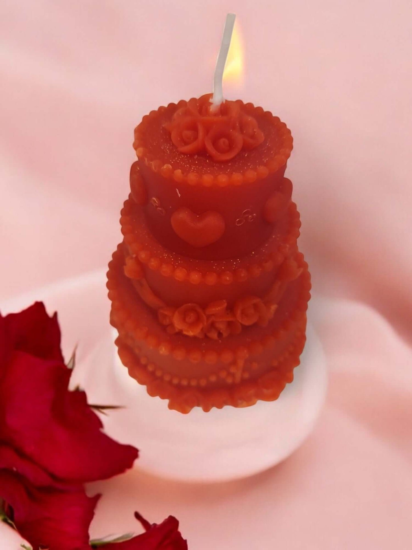 Sensual red massage candle shaped like a three-tiered cake, perfect for intimate moments and erotic play.