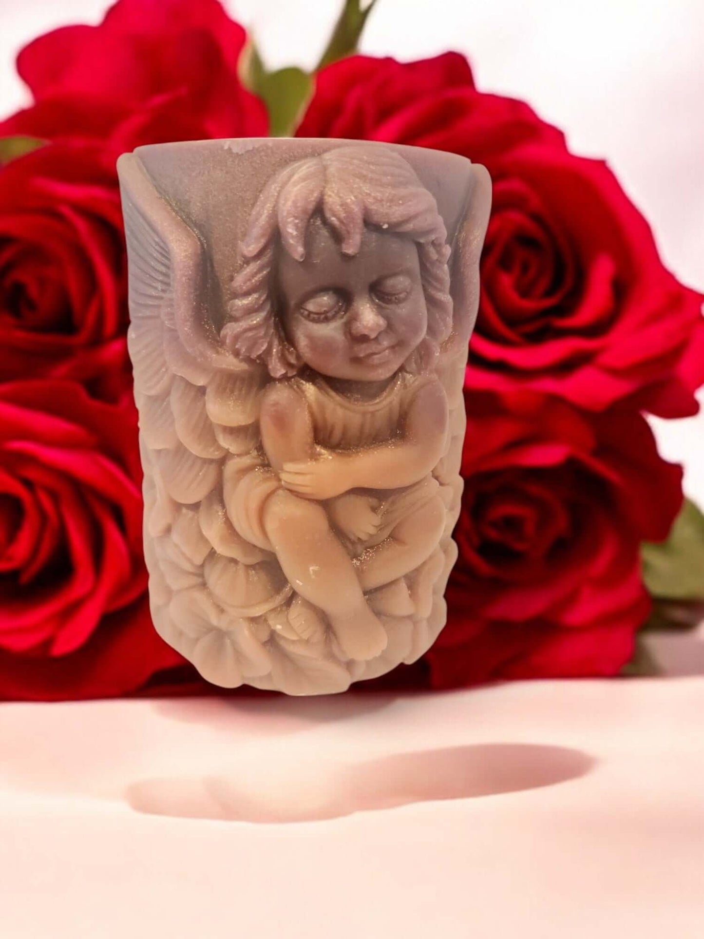 Angel Wing candle holder with an angel figurine, surrounded by vibrant red roses, ideal for romantic settings.