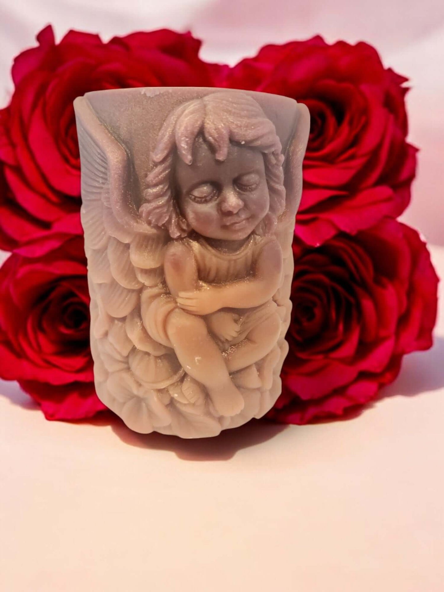 Angel Wing candle next to red roses, ideal for sensual massages and enhancing intimacy.
