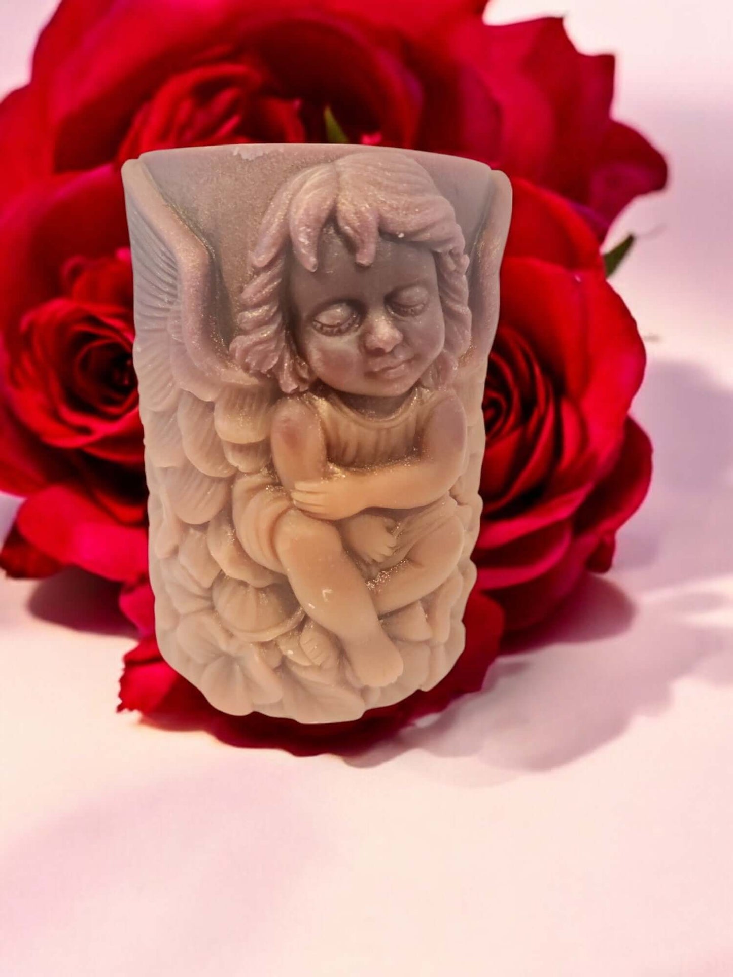 Sensual massage candle shaped like a cherub angel, surrounded by red roses, perfect for enhancing intimacy and relaxation.